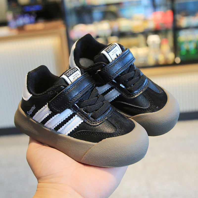 Image of a black and white sneaker with a thick sole and a mesh upper, featuring a lace-up design.